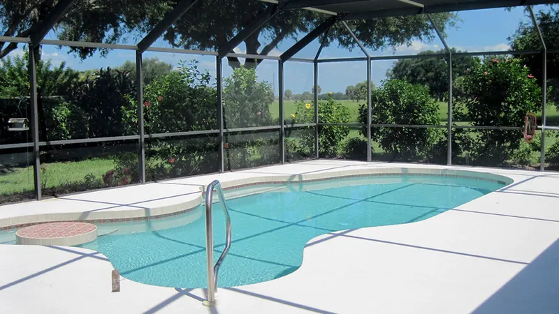 Inside a screened pool enclosure in Sarasota, Florida, with a clean pool deck